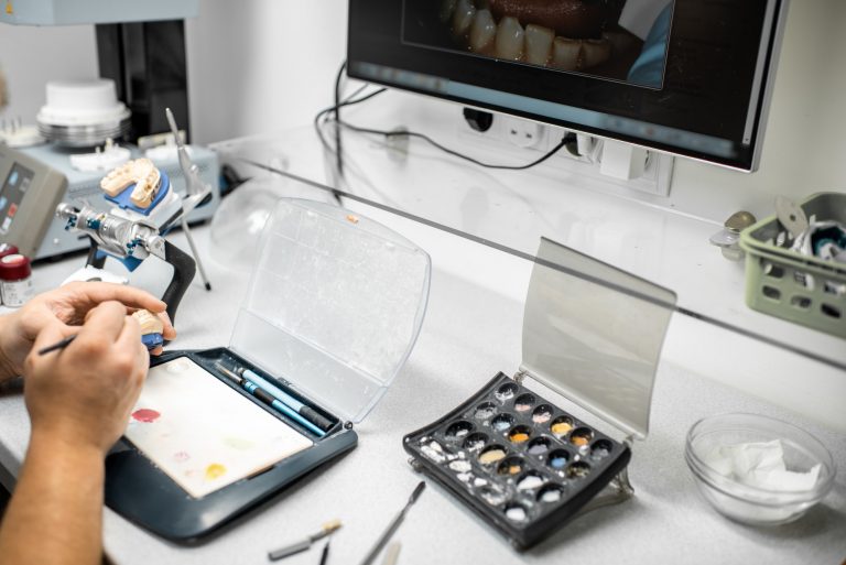Dental technician coloring dental prosthesis